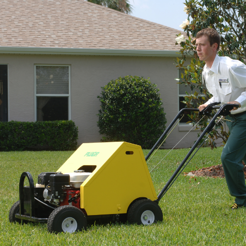 Massey Services technician using a lawn aerator.